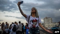 Una joven youtuber cubana graba un video en el Malecón habanero. 