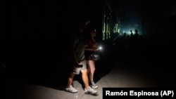 Cubanos caminan por una calle iluminadas con linternas durante un apagón en La Habana. Foto: AP/Ramón Espinosa 
