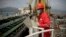 Trabajador de PDVSA observa un carguero de petróleo con bandera iraní en Puerto Cabello, una de las refinerías de la petrolera estatal venezolana.
