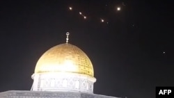 Una captura de imagen de un vídeo tomado a primera hora de este domingo, 14 de abril, muestra estelas de cohetes en el cielo sobre la Mezquita de Al-Aqsa, en Jerusalén.