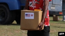 Voluntarios de Cáritas entregan ayuda humanitaria enviada por el gobierno de EEUU a pobladores de Hongolosongo, en El Cobre, Santiago de Cuba. 