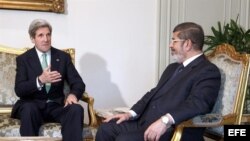 El presidente de Egipto, Mohamed Mursi (dcha) conversa con el secretario de Estado de Estados Unidos, John Kerry (izq).