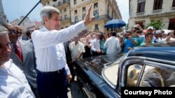 Kerry saluda a los cubanos antes de montarse en un viejo Chevrolet Impala en La Habana.