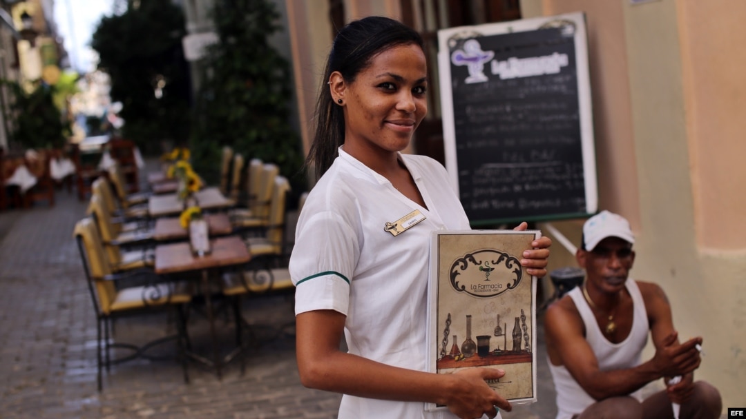 Una mesera posa mientras espera la llegada de clientes en un restaurante privado en La Habana.