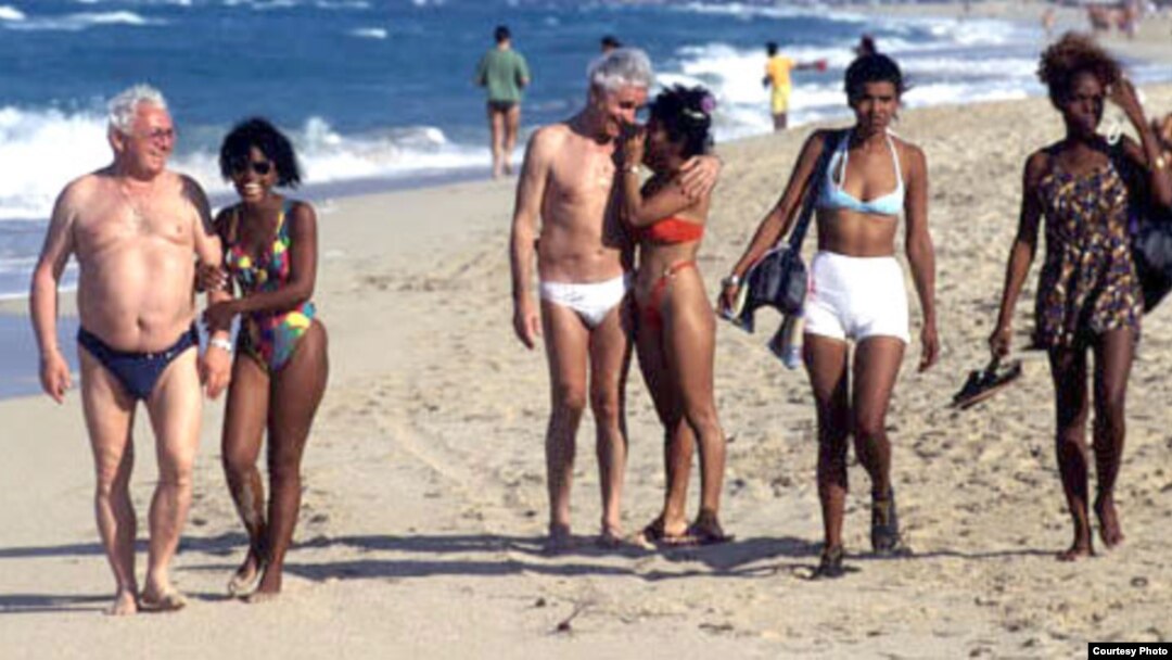 Adolescentes con extranjeros de edad muy avanzada en una playa cubana.