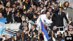 El papa Francisco besa a un niño mientras saluda a los miles de fieles en la plaza de San Pedro en el Vaticano hoy, martes 19 de marzo de 2013. El papa Francisco llegó hoy a la plaza de San Pedro para recorrerla entre los fieles antes de comenzar la misa 