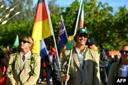 El surfista sudafricanos Jordy Smith (d) y el sudafricano Matthew Mcgillivray, marchan en un desfile, de la ceremonia de apertura de los Juegos Olímpicos de París 2024, en la isla de Tahití, en la Polinesia Francesa, el 26 de julio de 2024. (Foto de Jerome BROUILLET / AFP)