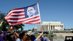 Una mujer enarbola una bandera estadounidense con la imágen del presidente Barack Obama en el acto por el 50 aniversario del discurso de Martin Luther King.