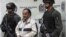 Archivo - Efectivos de la policía colombiana escoltan a Hely Mejía Mendoza (c), destacado cabecilla de las FARC conocido con el alias de 'Martín Sombra', quien fuera capturado en el departamento de Boyacá y presentado hoy, 26 de febrero de 2008, en Bogotá