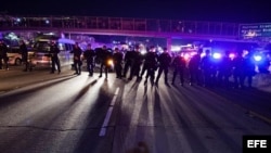 Policías forman en fila para enfrentarse a los violentos manifestantes.