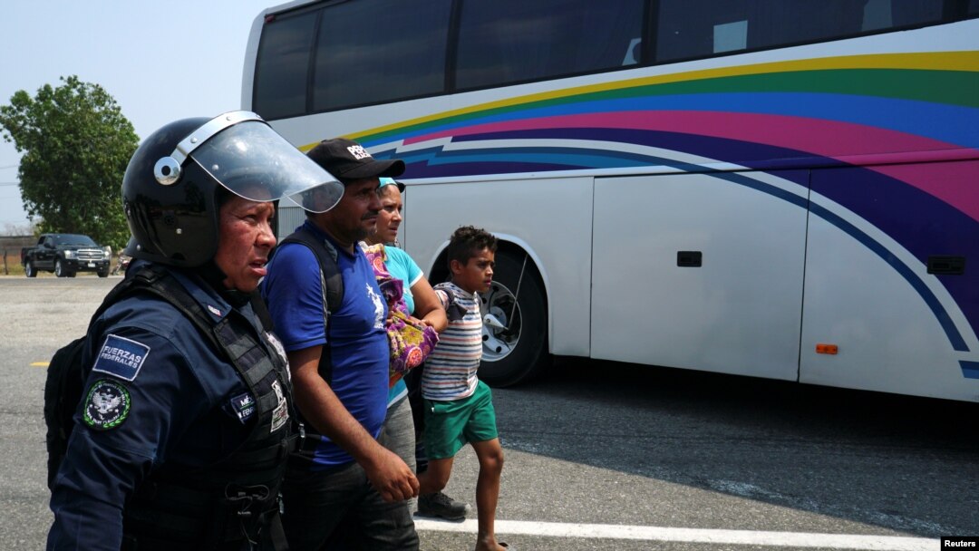 Una familia de migrantes centroamericanos es detenida por un policía federal en Mapastepec, México. 