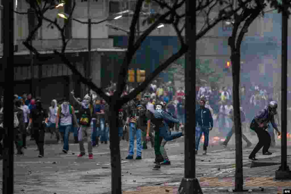 Manifestantes se enfrentan a miembros de la Guardia Nacional Bolivariana (GNB) hoy, jueves 12 de febrero de 2015, durante protestas en recuerdo de los fallecidos hace un año al término de una manifestación de la oposición, lo que dio inicio a un ola de pr