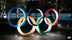 Los anillos olímpicos frente al nuevo Estadio Nacional de Tokio. 