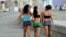 Tres mujeres caminan por el malecón. 