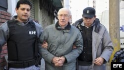 Fotografía de archivo del 17 de julio de 2012 en la que se observa al exdictador argentino Jorge Rafael Videla (c) escoltado por la policía en la localidad de San Martín, provincia de Buenos Aires (Argentina). 