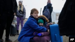 Una mujer y una niña en un paso fronterizo de Ucrania intentan huir de la violencia perpetrada por fuerzas rusas. (AP Foto/Markus Schreiber).