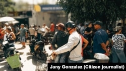 Personas hacen fila frente a la Mipyme "La Pequeña Isla", en Santa Clara, para comprar una balita de gas.