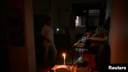 Residente de Caracas se ilumina en su casa con velas por apagón resgistrado durante horas de la noche. (REUTERS)