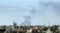 Una columna de humo, que se cree fue provocada por unas explosiones cerca del Aeropuerto Internacional de Trípoli, se eleva sobre el cielo de la capital libia.