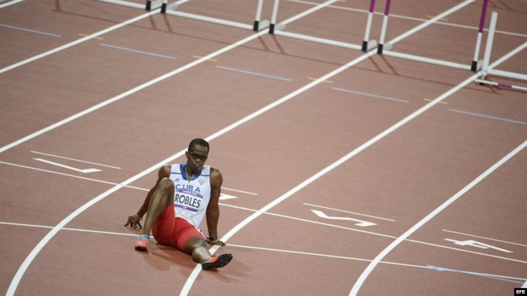 El cubano Dayron Robles se sienta en la pista en frustración por no terminar la prueba de los 110 metros vallas masculino. 