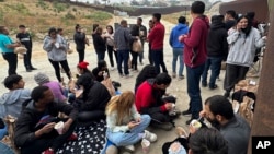 Los migrantes que buscan asilo descansan mientras esperan ser procesados ​​después de cruzar la frontera el miércoles 5 de junio de 2024, en San Diego, California. Foto AP/Eugene García