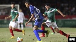 El jugador Armando Zamorano (d), de México, y Adrián Díaz (i), de Cuba, disputan un balón.