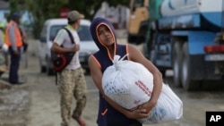 Un niño carga un saco de donaciones después de que el huracán Oscar azotara la ciudad de Imías, en la provincia de Guantánamo. (AP/Ariel Ley, Pool)