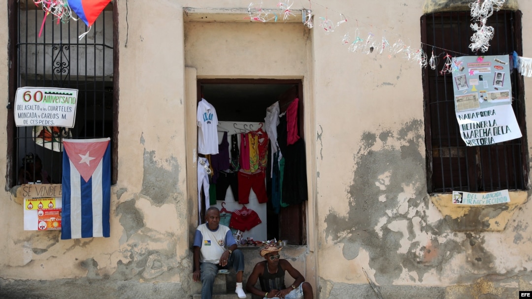 Dos hombres conversan en la entrada de una casa en la ciudad de Santiago de Cuba.