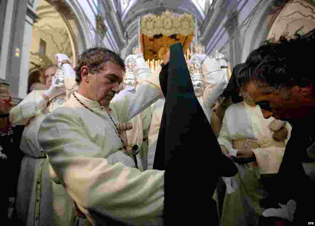 Banderas se dispone a colocarse el capillo para la procesión del Domingo de Ramos en Málaga. 