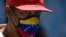 Un hombre viste una mascarilla con la bandera de Venezuela en una calle de Caracas. (AP/Matias Delacroix)
