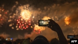Unas personas observan los fuegos artificiales durante la celebración del Día de la Independencia «Salute to America» en Washington D. C., en la madrugada del 5 de julio de 2026.