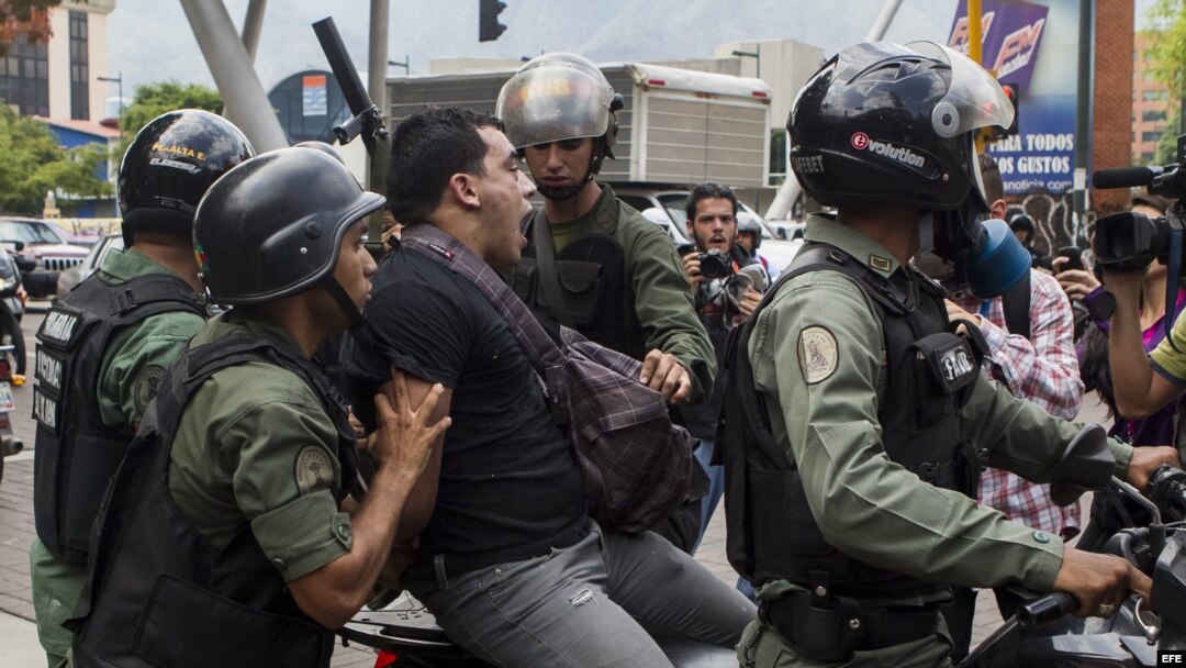 Miembros de la Guardia Nacional Bolivariana detienen a un manifestante durante una marcha de opositores.