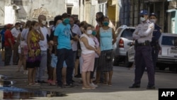 La policía controla la cola en tienda en dólares. (Adalberto ROQUE / AFP)