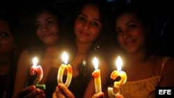 Jóvenes sostienen velas con el número 2013 durante las celebraciones del nuevo año en Bhopal (India). 