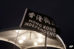 Una bandera ondea con el lema ''Independencia de Hong Kong'' durante una vigilia con velas en la Plaza de la Democracia en Taipei, el martes 4 de junio de 2024, para conmemorar el aniversario de la represión china en la Plaza de Tiananmen de Pekín. (AP Photo/Chiang Ying-ying)
