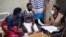 Una gerente de casos en Ruanda reunida con clientes para hablar sobre la prevención de VIH y su medicación. (© Albert Mamasi/AEE Ruanda)