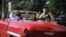 Un turista toma fotos desde un carro en La Habana.