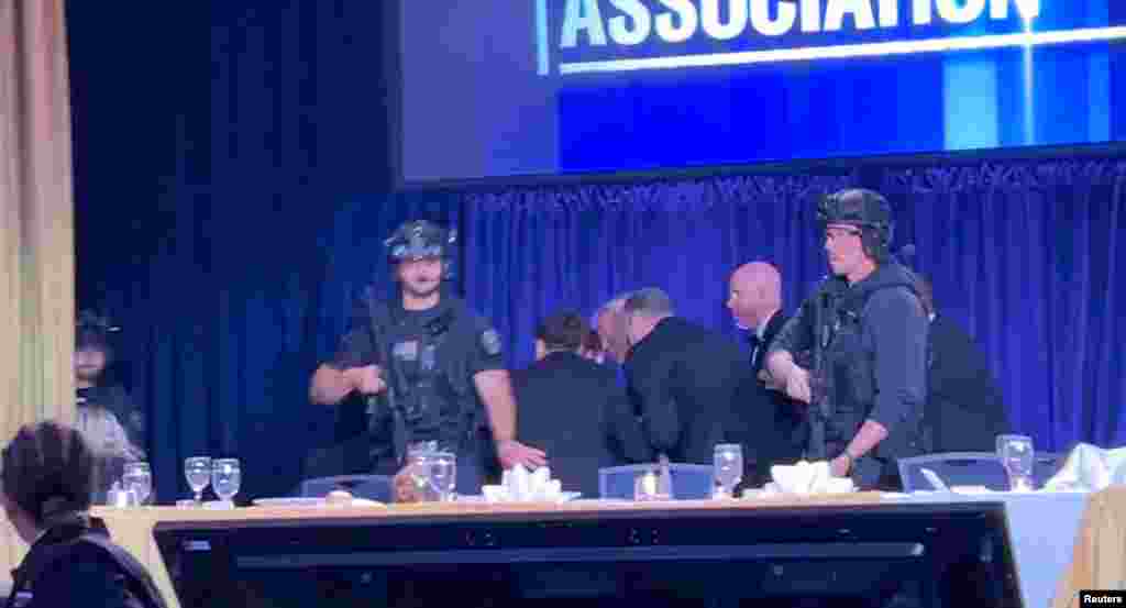 El presidente de EEUU, Donald Trump, es escoltado fuera del salón donde ocurría el evento, luego de que se escucharan disparos.