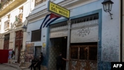 Trabajadores permanecen de pie frente a la emblemática Bodeguita del Medio, en La Habana Vieja, vacía debido a la falta de turistas en la ciudad.