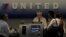 Pasajeros facturan para su vuelo en un mostrador de United Airlines.