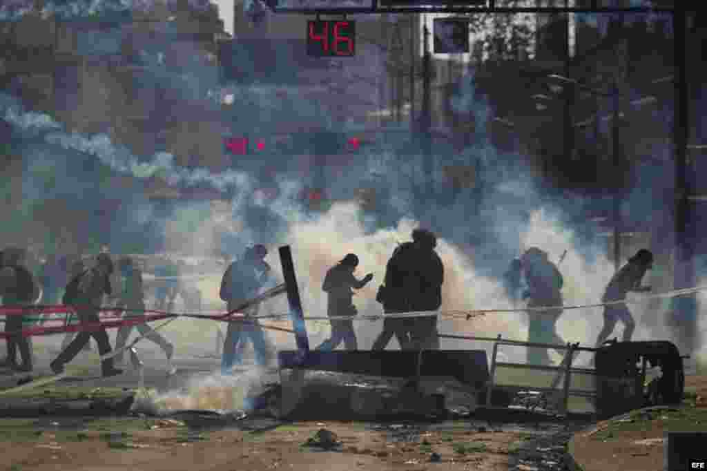 Un grupo de manifestantes se defienden de la policía durante una protesta