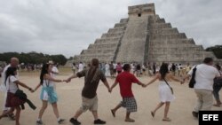 Varias personas participan junto a grupos tradicionalistas de la cultura maya, en un ritual cerca de la pirámide de Kukulkán, en Chichen Itzá,México.