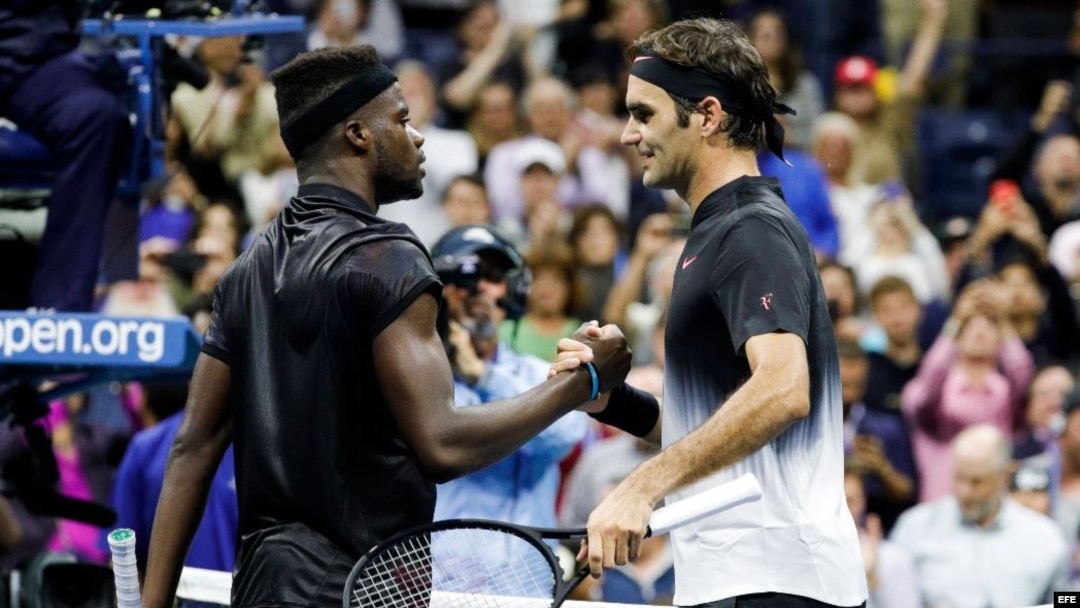 Roger Federer (d) saluda a Frances Tiafoe (i) tras concluir el encuentro que disputaron en el Abierto de Estados Unidos 2017. 