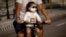 Una niña transportada en bicicleta usa un nasobuco para evitar el contagio del coronavirus, en La Habana, Cuba. AP Photo/Ramon Espinosa