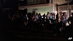 La policía nacional patrulla entre los manifestantes que piden el restablecimiento de los servicios eléctricos en La Habana, Cuba, en septiembre de 2022. (Foto AP/Ramon Espinosa)