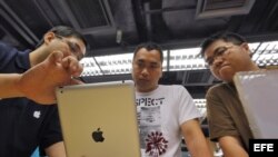 YHKG05 HONG KONG (CHINA), 16/2/2012.- Fotografía de archivo fechada el 29 de abril de 2011 de unos clientes echando un vistazo a un iPad 2 de Apple en Hong Kong, China. Varios puntos de venta de productos informáticos en internet y otros tradicionales han