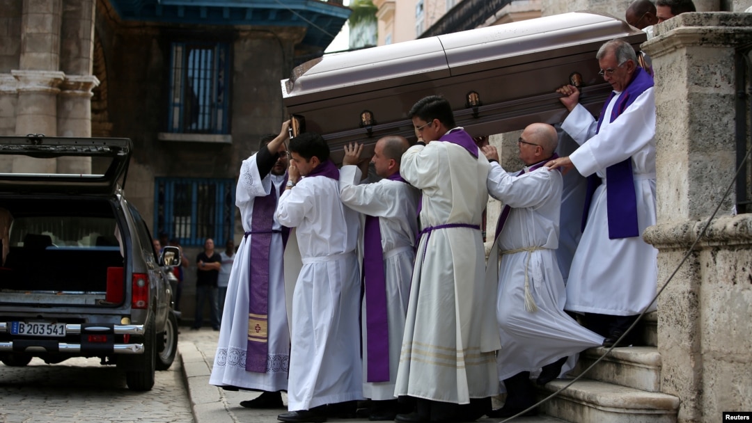 Miembros del clero cargan el ataúd con los restos del cardenal Jaime Ortega Alamino. 