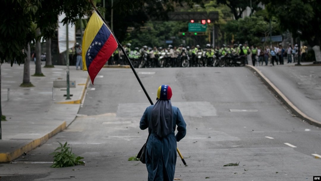 Un manifestante camina frente a efectivos de la Policía Nacional Bolivariana (PNB) el 7 de junio de 2017, en Caracas.