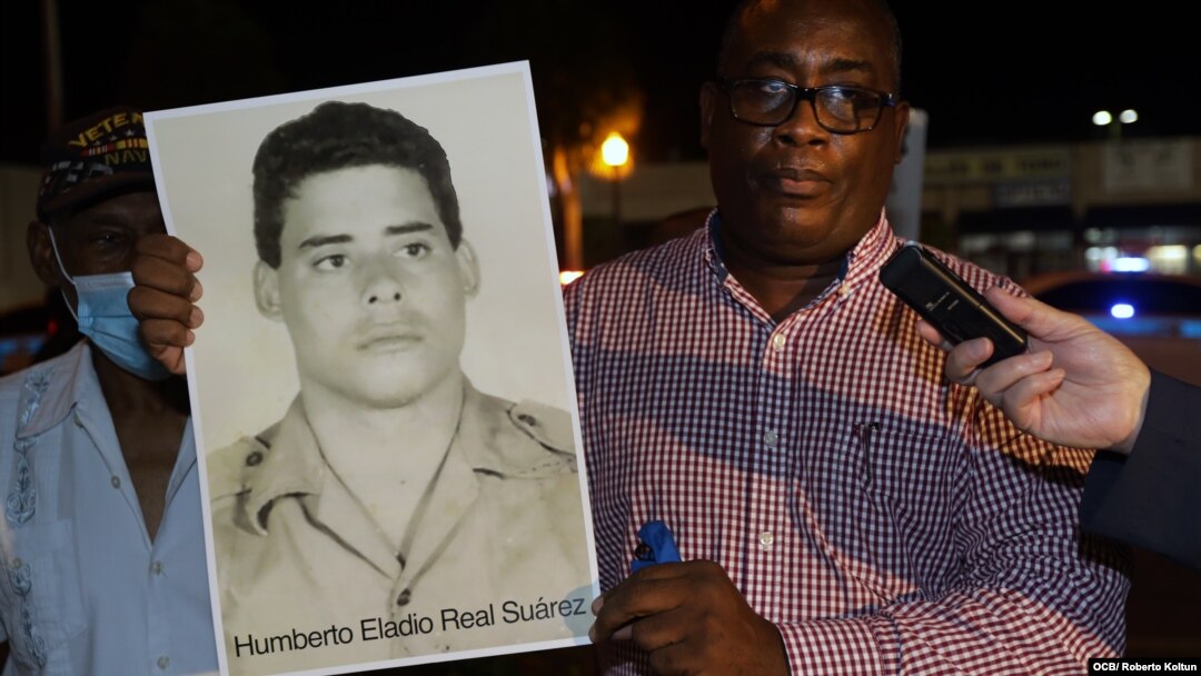 Jorge Luis García, "Antúnez" (I) sostiene una foto de Humberto Eladio Real Suárez, condenado a 30 años de cárcel en 1994 y ganador del Premio Libertad Pedro Luis Boitel 2020. (OCB/Roberto Koltun/Archivo)