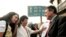 Magalys de Armas, esposa del opositor Vladimiro Roca, y su hija saludan a Michael Georges Kozak(R), en el Tribunal Municipal de Marianao. AFP/ADALBERTO ROQUE 